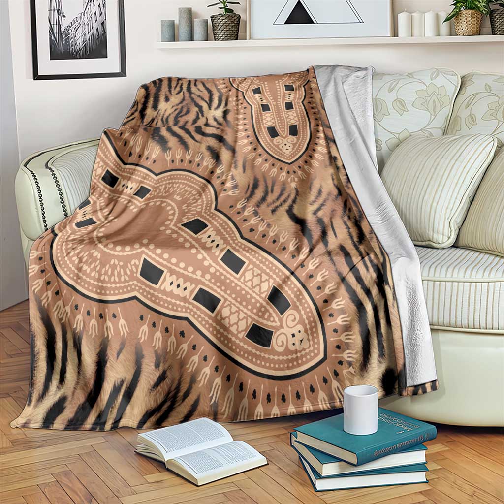 Tiger-striped dashiki blanket in brown and beige, draped over sofa with books nearby