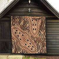 Beige tribal medallion quilt hanging on front of wooden shed
