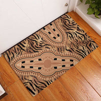 Beige tiger-stripe tribal rubber doormat on wooden floor with central medallion