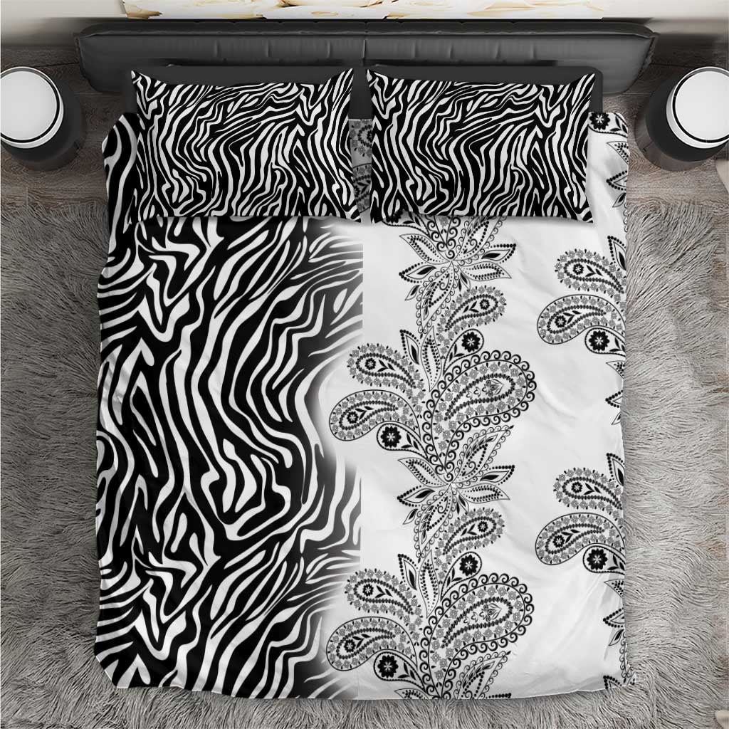 Black and white bedding set laid flat with zebra stripes and vertical paisley floral design