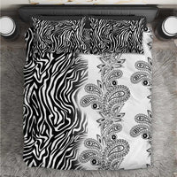 Black and white bedding set laid flat with zebra stripes and vertical paisley floral design