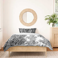 Black and white bedding set on bed with zebra stripe fabric and paisley floral design