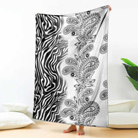 Black-and-white zebra and paisley tribal blanket, shown hanging over bed edge