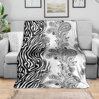 Black-and-white zebra and paisley tribal blanket, spread on gray couch