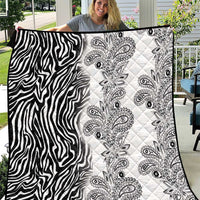 Black-and-white quilt featuring zebra stripes on one side and paisley motifs on the other.