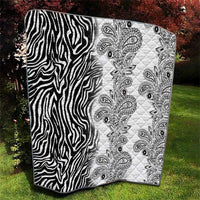 Black-and-white quilt blanket with zebra stripe panel and ornate paisley pattern panel.