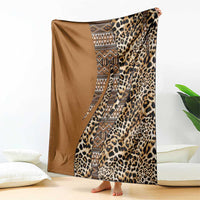 Gold-brown and leopard print blanket with geometric tribal stripe, shown hanging and folded.