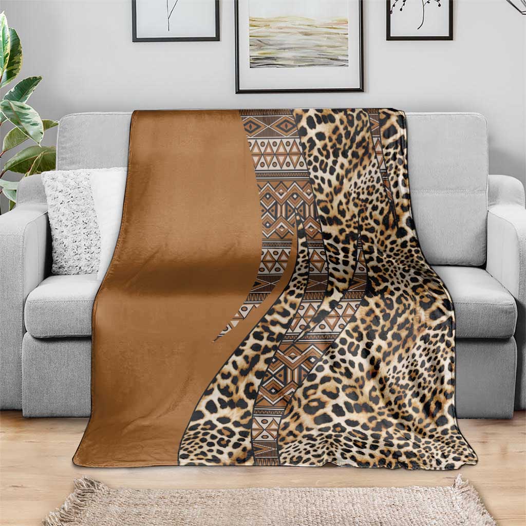 Leopard and tribal pattern blanket with gold-brown solid border, draped on a couch.