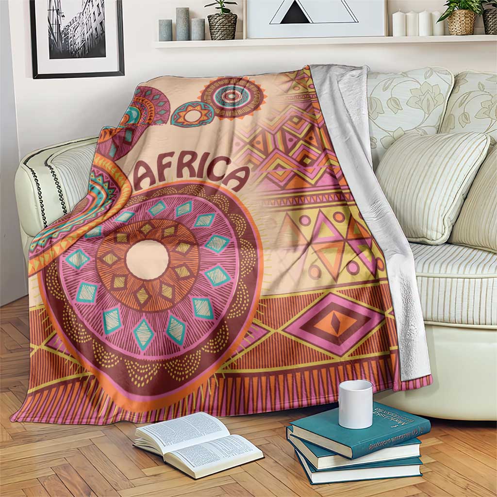 Beige tribal pattern blanket with 'AFRICA' text and multicolor circular motifs, geometric trim
