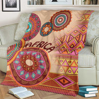 Beige Africa tribal pattern blanket draped on a couch, featuring 'AFRICA' and geometric motifs