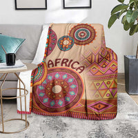 Beige tribal pattern blanket with 'AFRICA' text, multicolor mandala circles, and chevron shapes