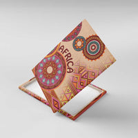 Tilted beige canvas wall art showing 'AFRICA' and colorful circular tribal motifs.