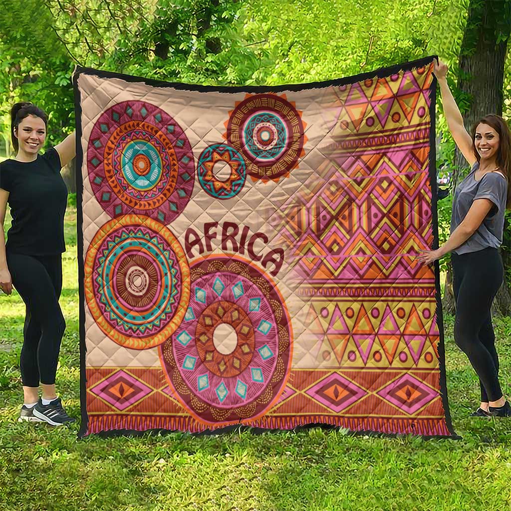 Beige outdoor quilt featuring large tribal circle motifs, 'Africa' lettering, diamond pattern