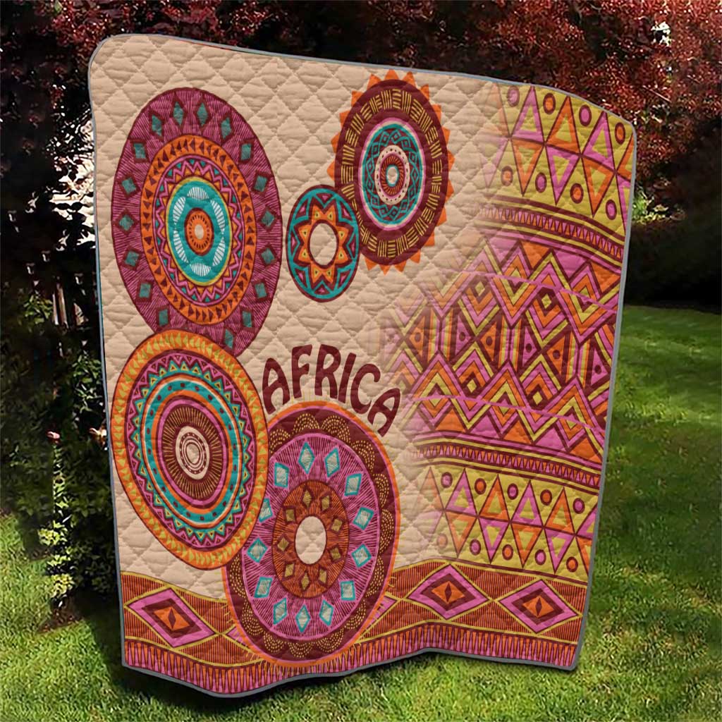 Beige tribal quilt blanket with 'Africa' and multicolor circle motifs, quilted texture