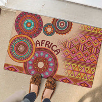 Beige tribal rubber doormat, angled view, multicolor circles and “AFRICA” lettering