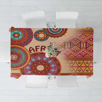Beige tribal tablecloth with colorful circular and diamond motifs and 'AFRICA' print.