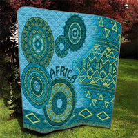 Blue tribal quilt with quilted texture, circular teal medallions, and geometric zigzag motifs.