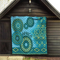 Blue tribal quilt hanging in a doorway, circular medallion designs and geometric border.