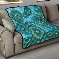 Blue tribal quilt on a couch with teal circular motifs, geometric diamonds, and “Africa” text.