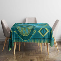Teal and blue patterned tablecloth with bold diamond shapes and fringed border