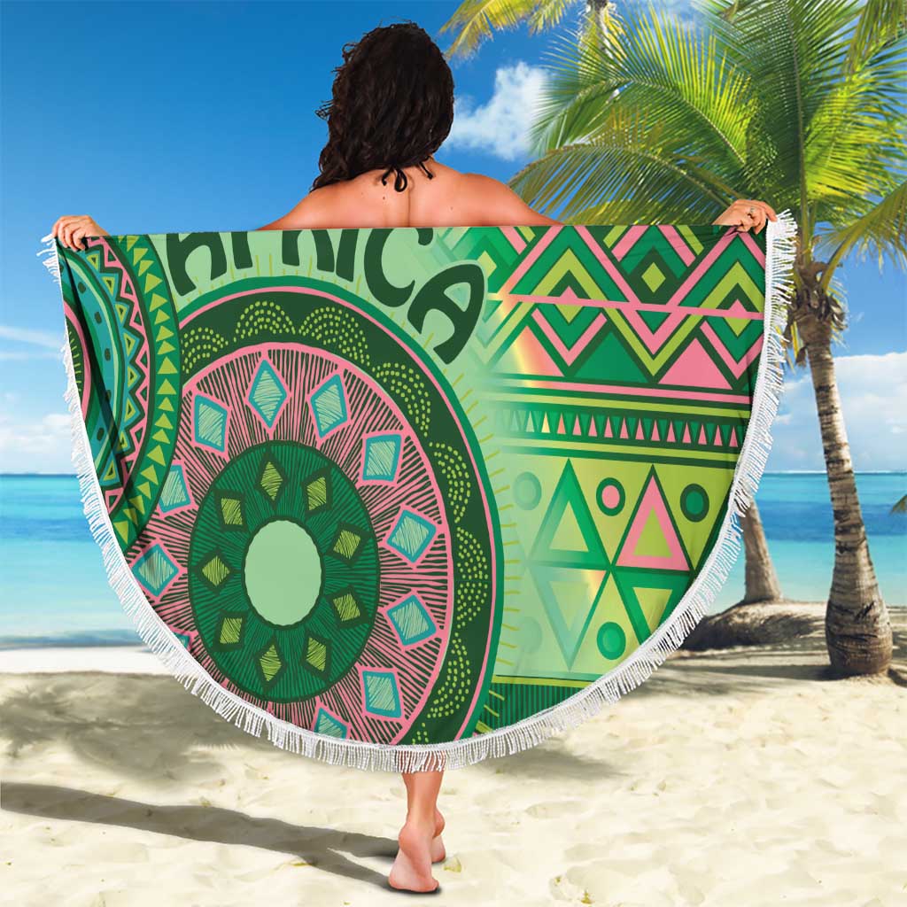 Fringed round beach blanket with green tribal design, 'AFRICA' text, pink and teal details