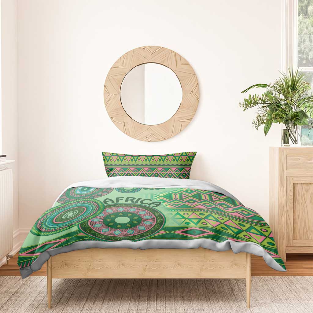 Green tribal bedding set duvet with circular medallion and 'AFRICA' lettering, on bed