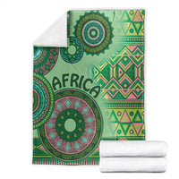 Green tribal pattern blanket with large circular medallion and geometric blocks