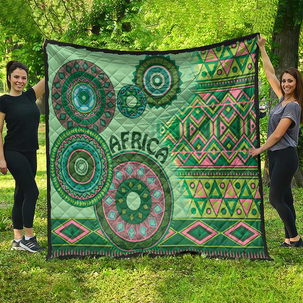 Green tribal pattern quilt with circular mandalas, zigzag bands, and dark edge border