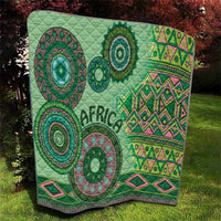 Green tribal quilt with quilted texture, circular mandala designs, and pink geometric bands