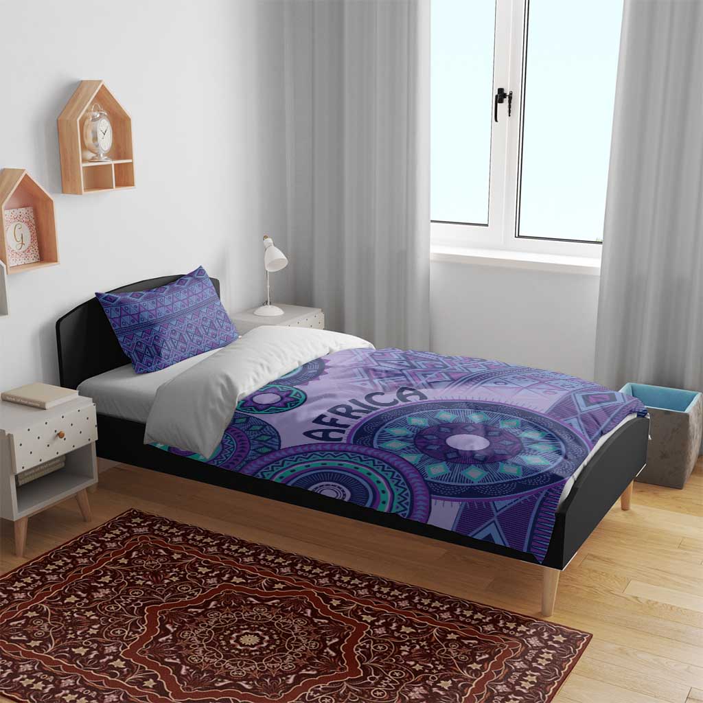 Purple bedding set on bed with tribal circle print duvet and two blue-patterned pillows