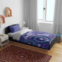Purple bedding set on bed with tribal circle print duvet and two blue-patterned pillows