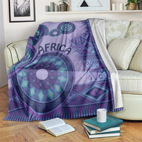 Purple tribal geometric blanket draped on sofa, large circular medallion motif