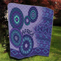 Purple quilt laid flat with quilted stitching, teal ring motifs, zigzags, and "AFRICA"
