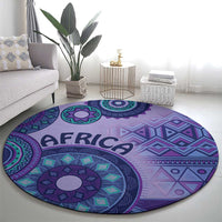Purple round area rug with teal and magenta geometric patterns and central flower medallion