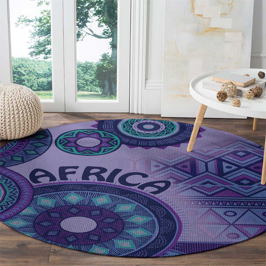 Purple round area rug with large teal medallion, geometric border, and AFRICA lettering