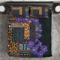 Dark bedding set viewed from above with tribal patchwork, purple flowers, leopard panel, 2 pillows