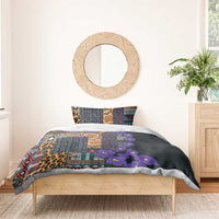 Dark bedding set on bed with tribal pattern, leopard panel, purple flowers, and 2 pillows
