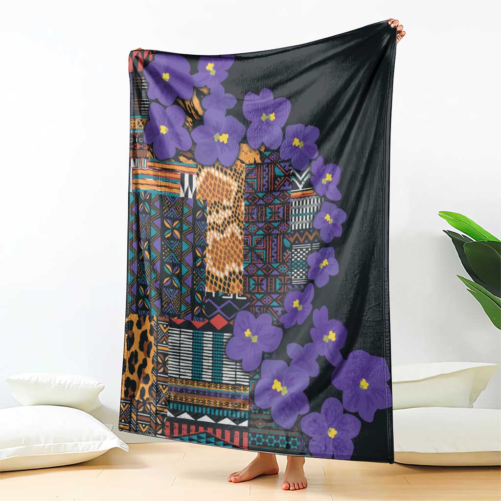 Dark tribal blanket featuring purple flowers and multicolor geometric design, draped view