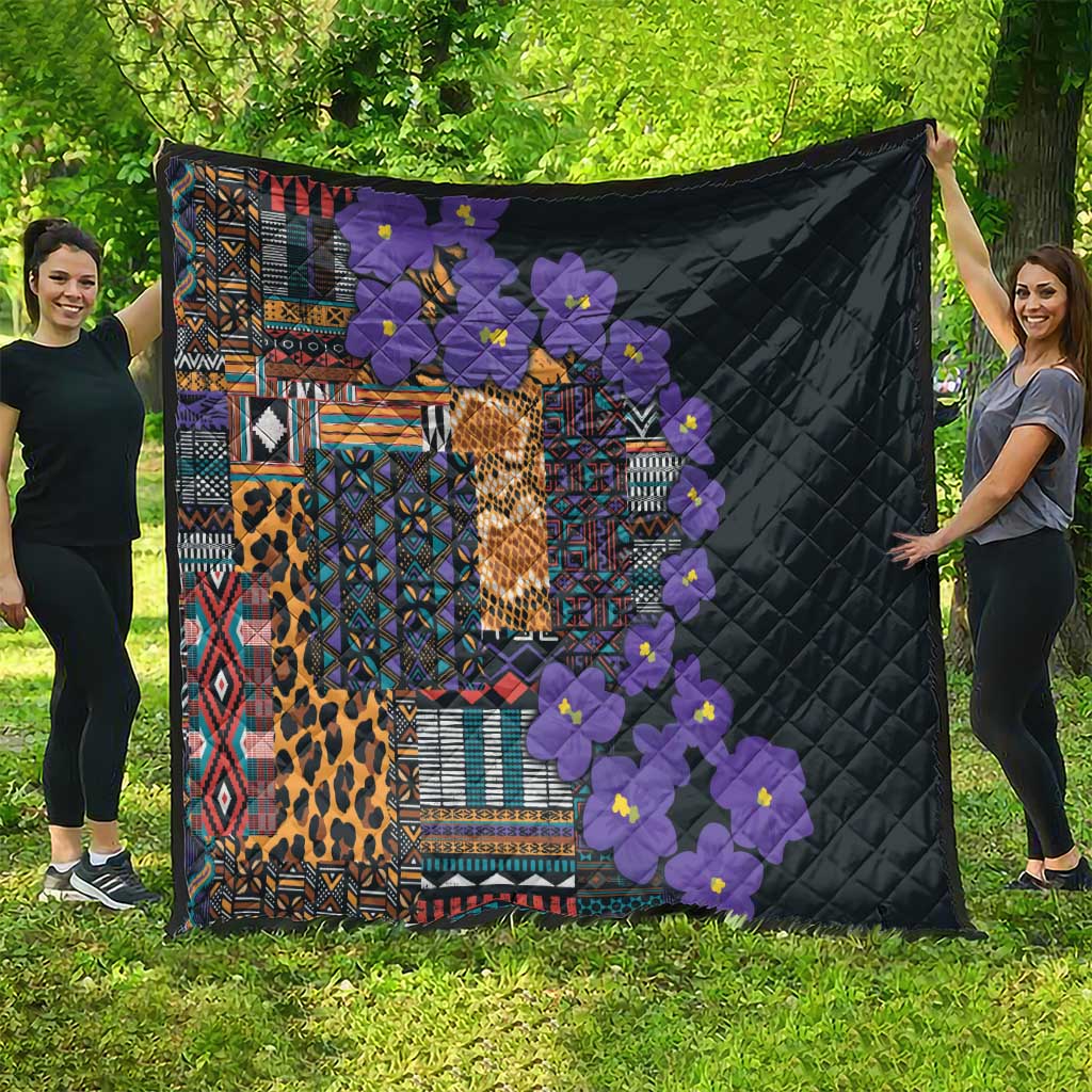 Black quilt with quilted diamond texture, colorful tribal blocks, leopard print, and purple flowers