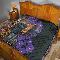 Quilt on bed with black base, colorful tribal border, leopard print, and purple flowers