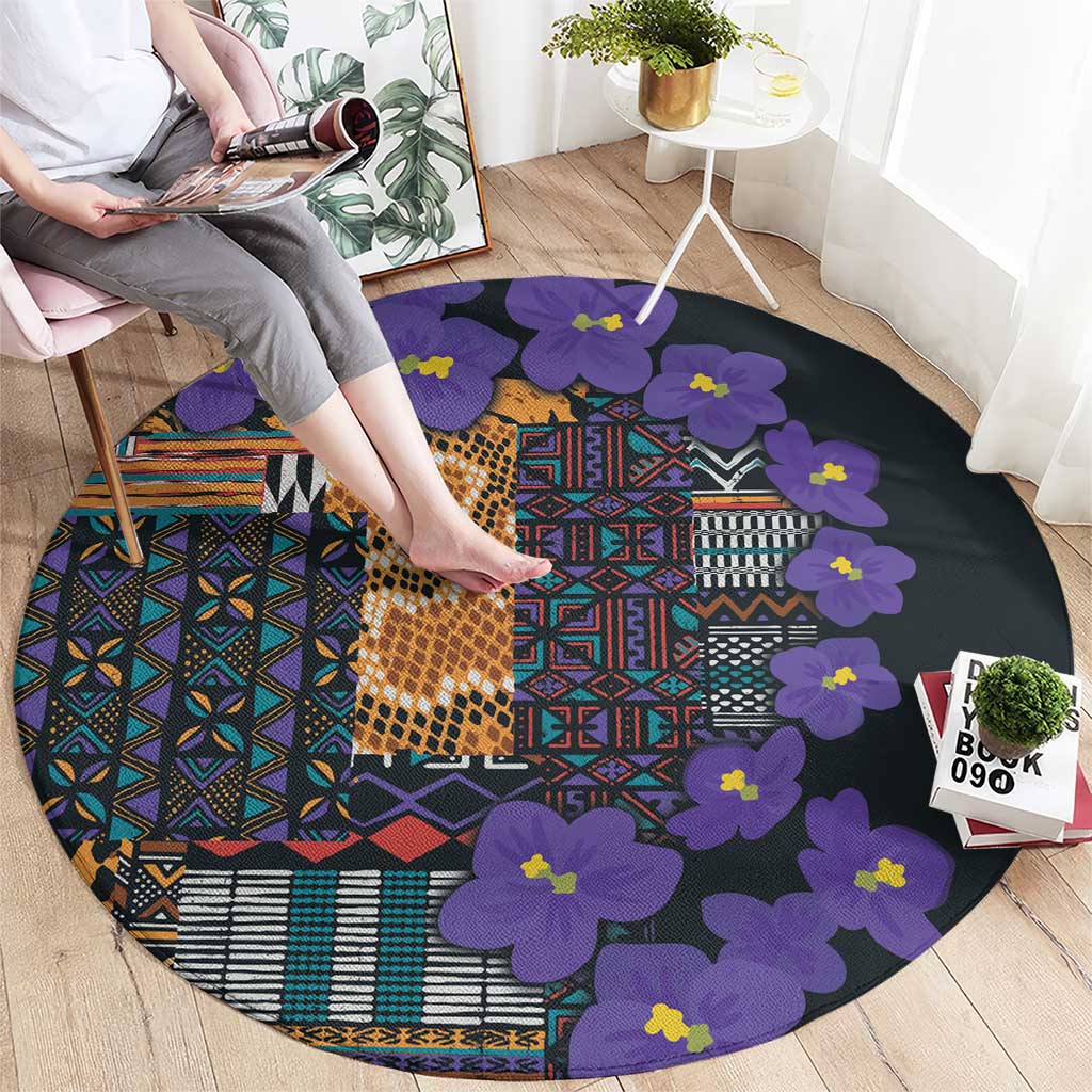 Round carpet with purple floral shapes and multicolor tribal block pattern on dark base