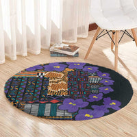 Round carpet with violet flower clusters and multicolor tribal stripes and blocks on dark base