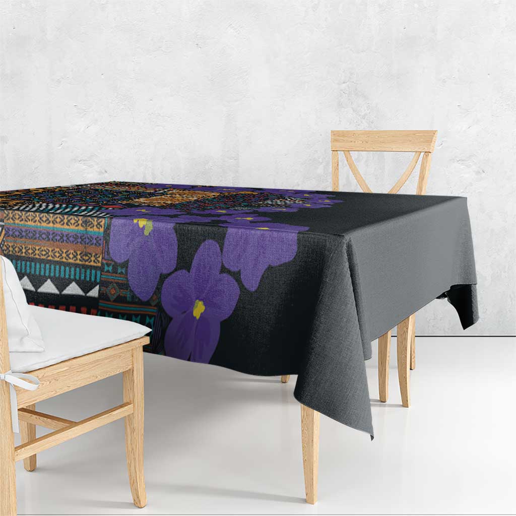 Tablecloth draped on a dining table, black with violet floral and tribal design.