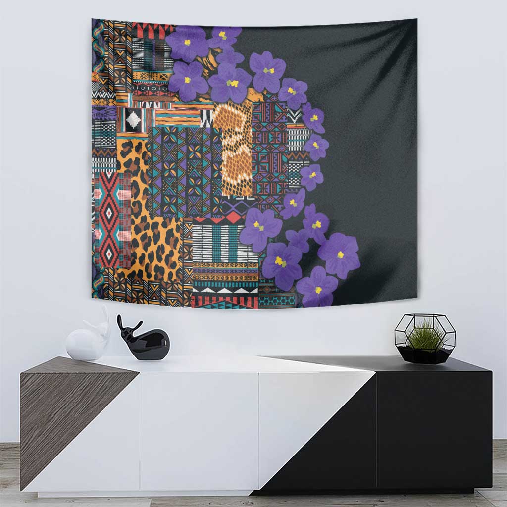 Wall tapestry with dark field, multicolor tribal blocks, leopard print, and purple flower garland