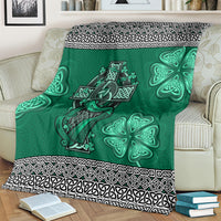 Green Celtic blanket spread on bed, harp and shamrock designs with patterned black border