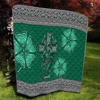 Green quilt with Celtic cross and harp centerpiece plus shamrock clovers, framed by patterned border.