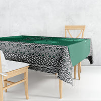 Green tablecloth draped over dining table with Celtic cross, harp, shamrock motifs