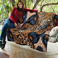 Black quilt draped on a couch with mixed animal prints and blue, orange circular designs