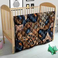 Black quilt laid on a baby bed with mixed animal prints and blue/orange circular motifs