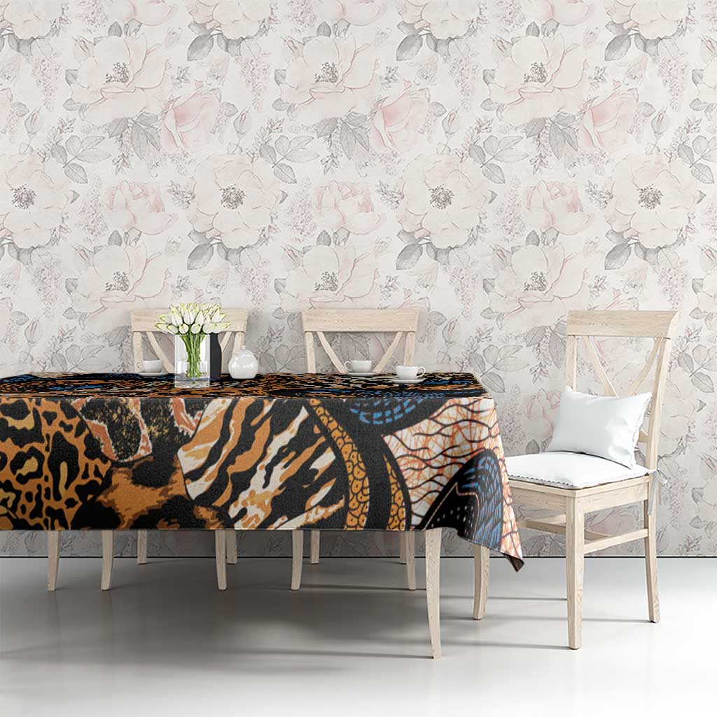 Dining table covered with animal-skin print tablecloth in black, tan, orange, and blue